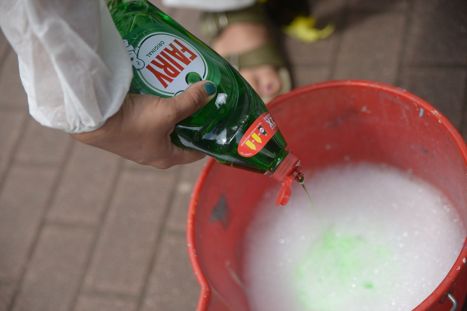 Un persona echa en un cubo lavavajillas