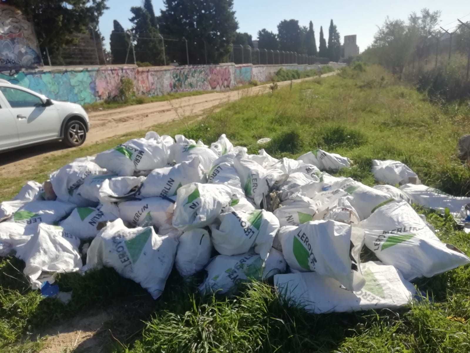 Vertido de sacos de escombros en Carabanchel, al fondo Santa María La Antigua