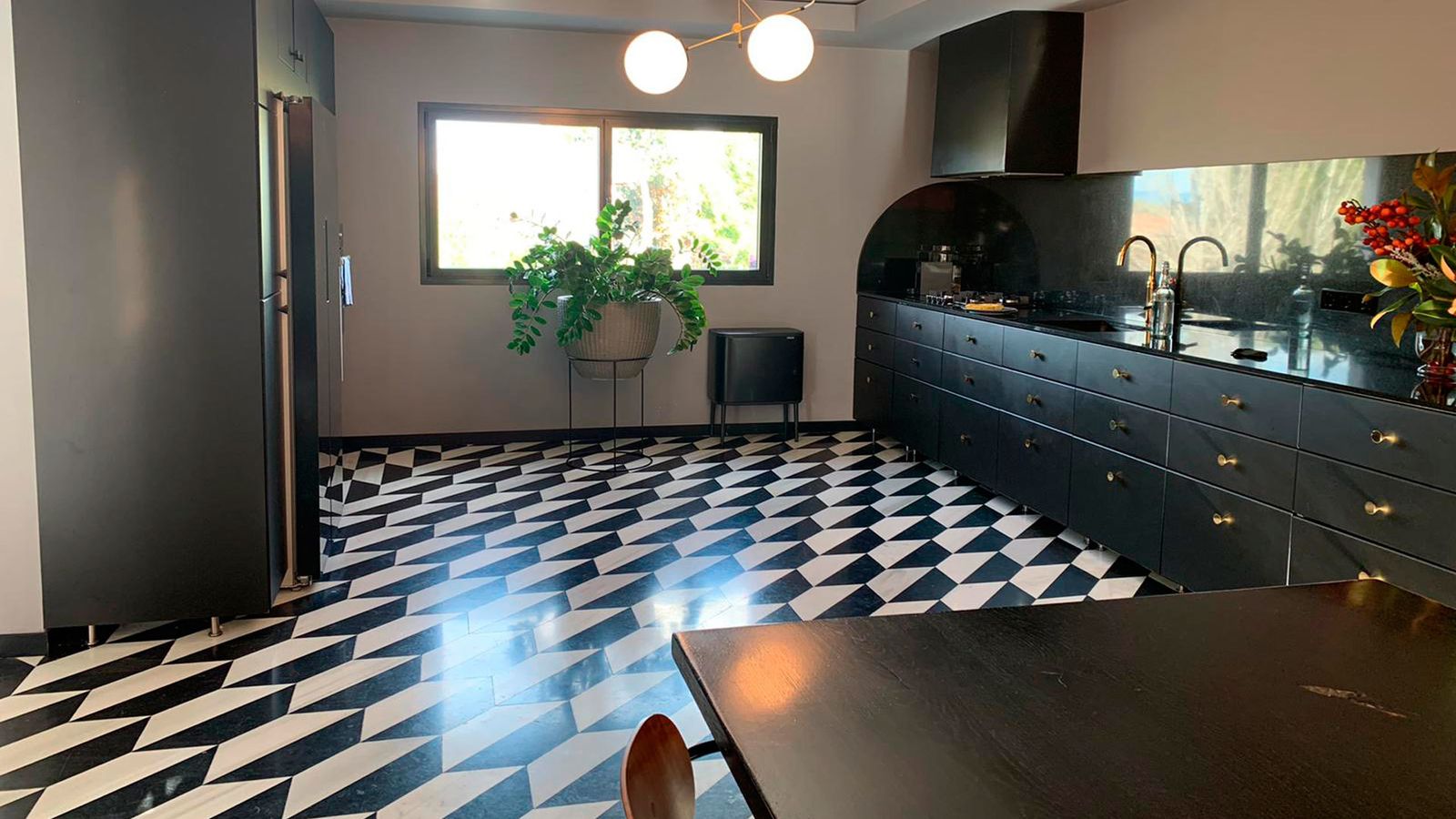 La cocina, en negro, está integrada por completo en el salón, sin separación de ningún tipo.