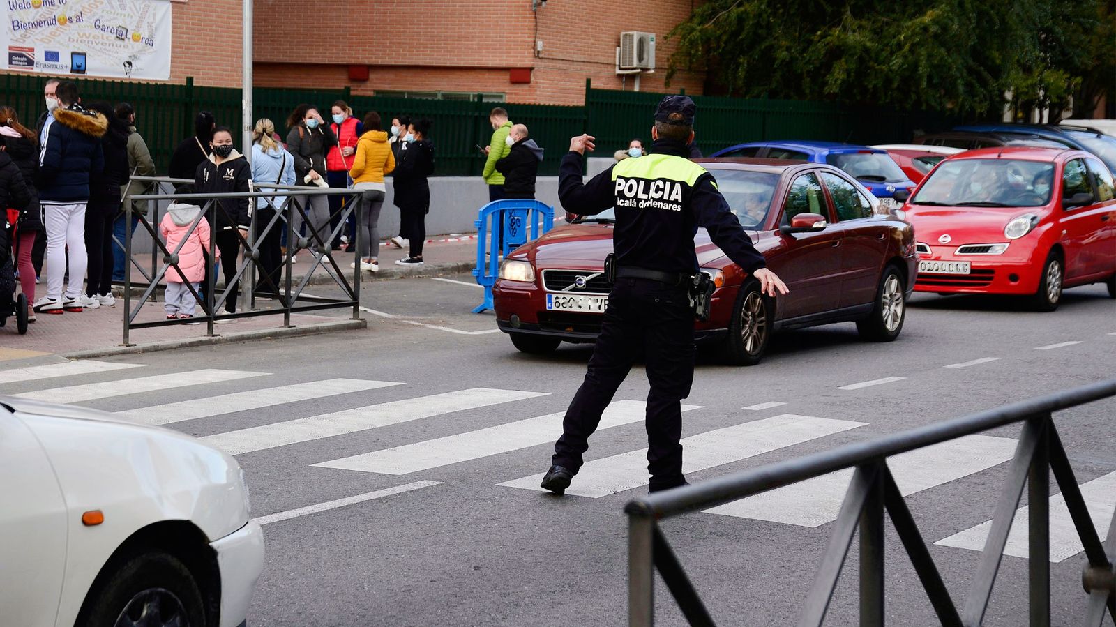 Un agente de la Policía Local de Alcalá de Henares regula el tráfico en las inmediaciones de un colegio