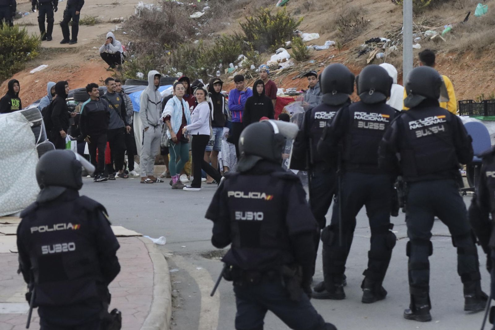Decenas de migrantes huyen por los montes de Ceuta tras desalojar la Policía las naves del Tarajal