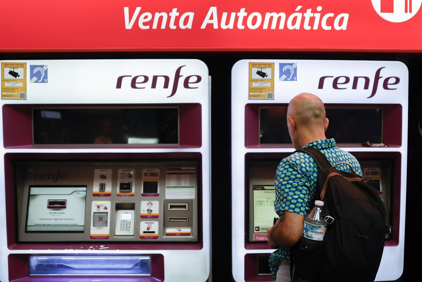 Viajeros gestionan la compra de sus abonos en máquinas  en una estación de Cercanías