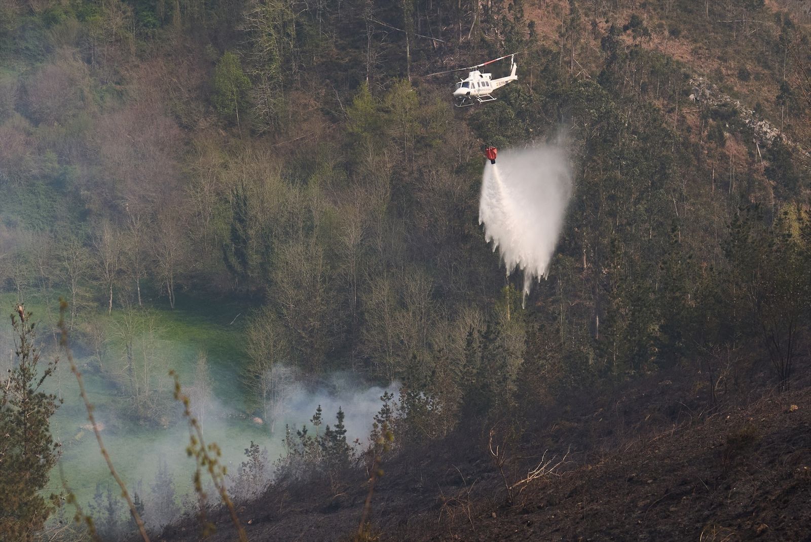 Medios aéreos trabajan en la extinción del fuego que afecta al Valle de Cabuérniga, Cantabria