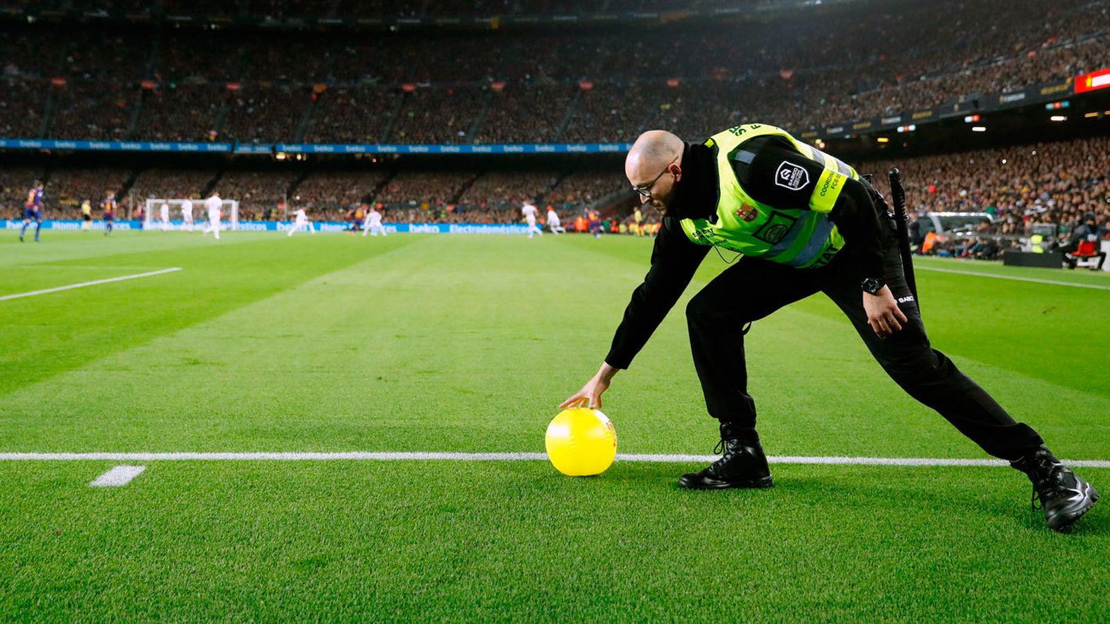 Miembros de seguridad del FC Barcelona retiran los balones amarillos lanzados al Camp Nou