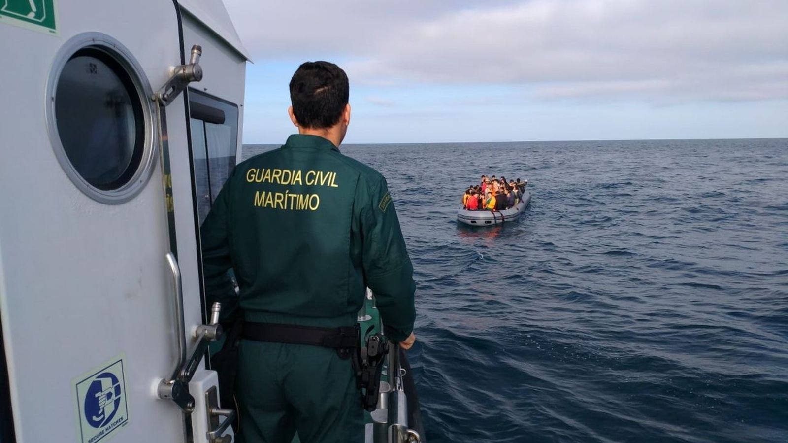 Embarcación de la Guardia Civil se aproxima a una patera para su rescate