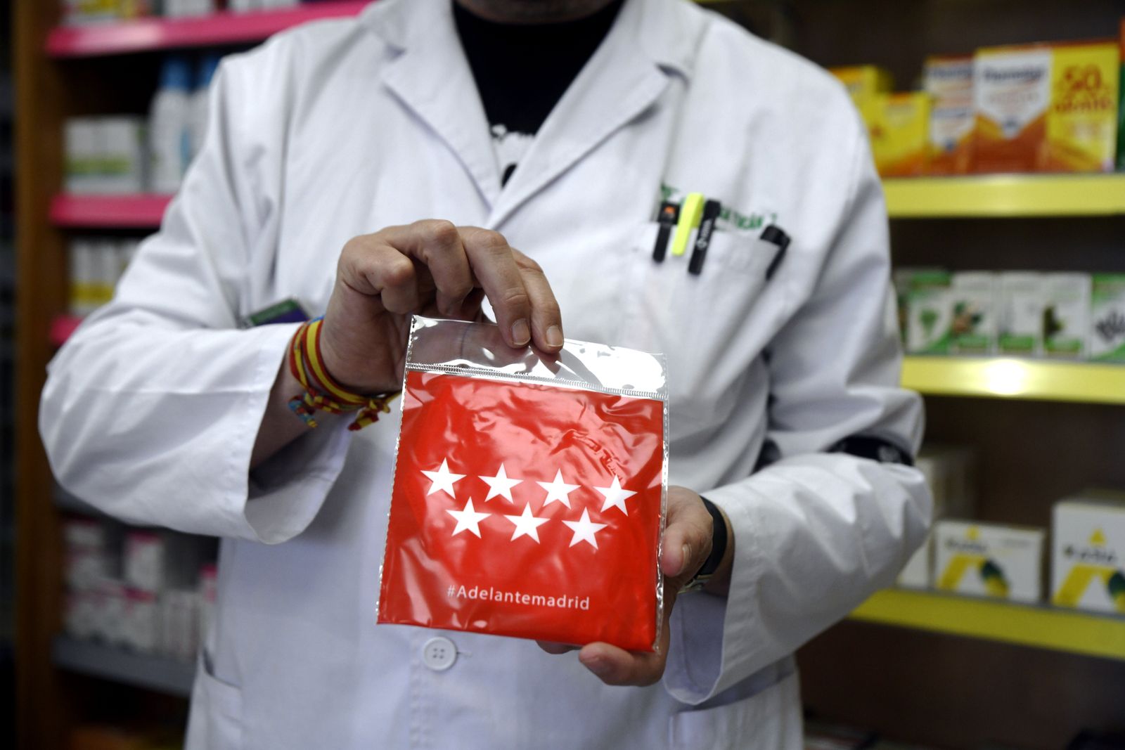 Un farmacéutico muestra una de las mascarillas repartidas por la Comunidad de Madrid