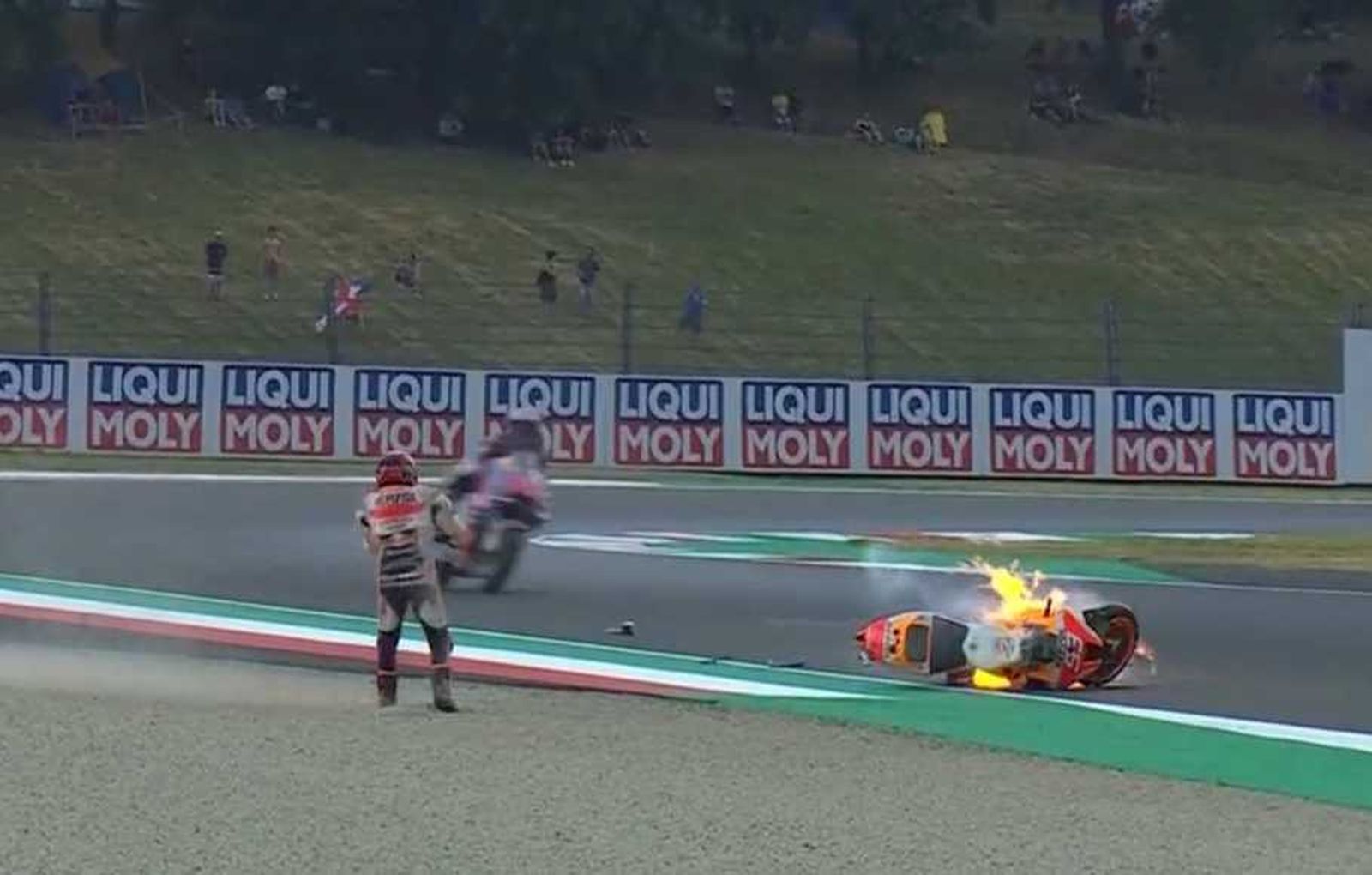 El piloto de Repsol Honda, Marc Márquez, mira su moto en llamas en el circuito de Mugello, Italia, el 28 de mayo de 2022