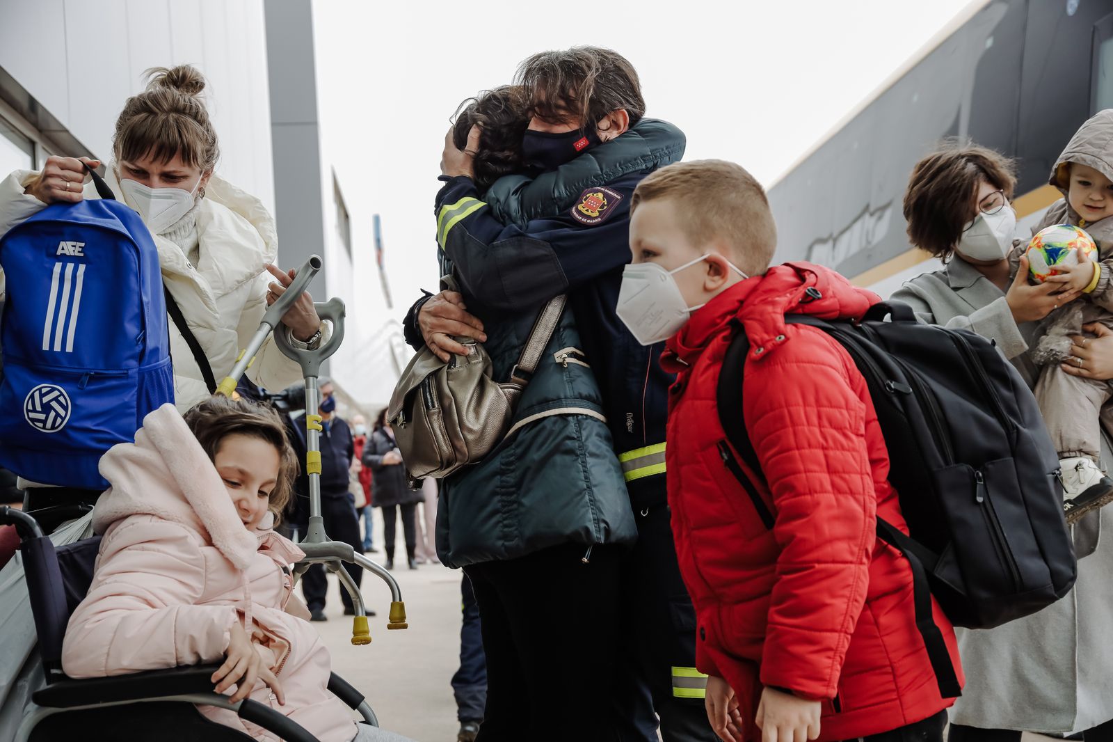 Un bombero abraza a una refugiada a su llegada al Hospital Zendal de Madrid