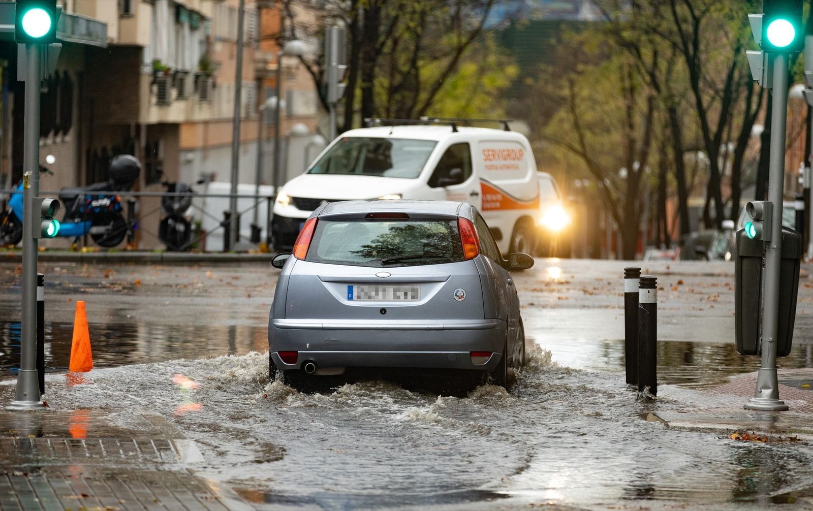 Un coche circula por una balsa de agua, en la Avenida de la Ciudad de Barcelona