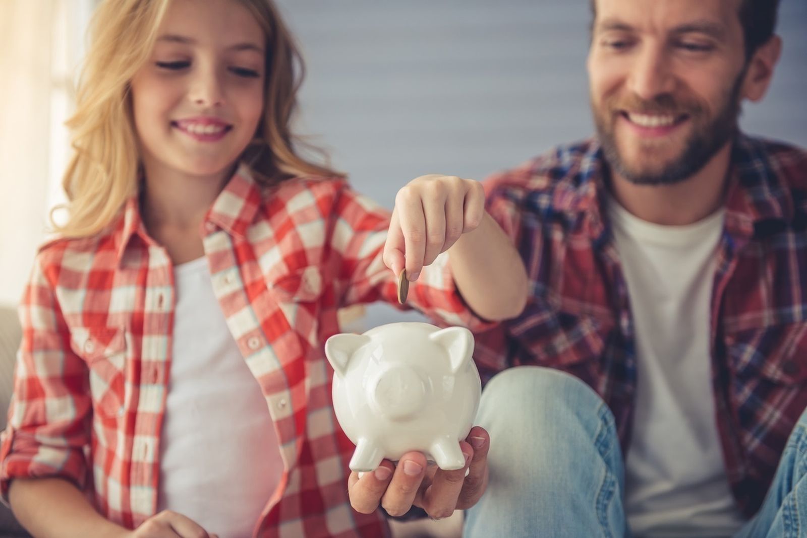 Padre e hija con una hucha