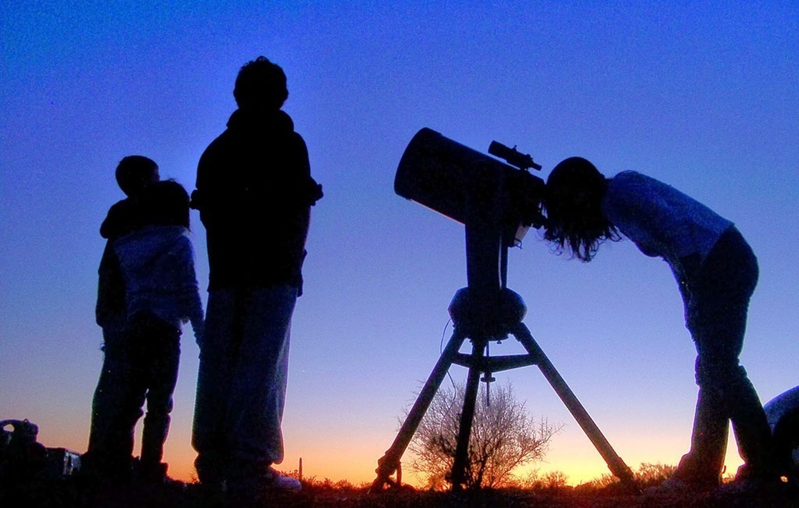 Personas observan el cielo con un telescopio