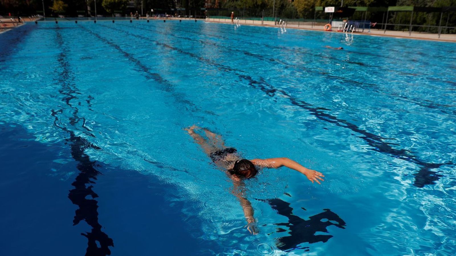 Una persona nada en una piscina municipal
