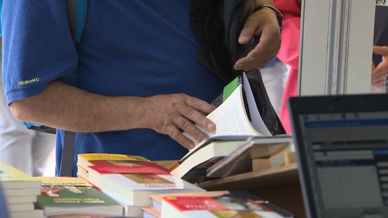 Un hombre mira un libro en la Feria del Libro de Madrid