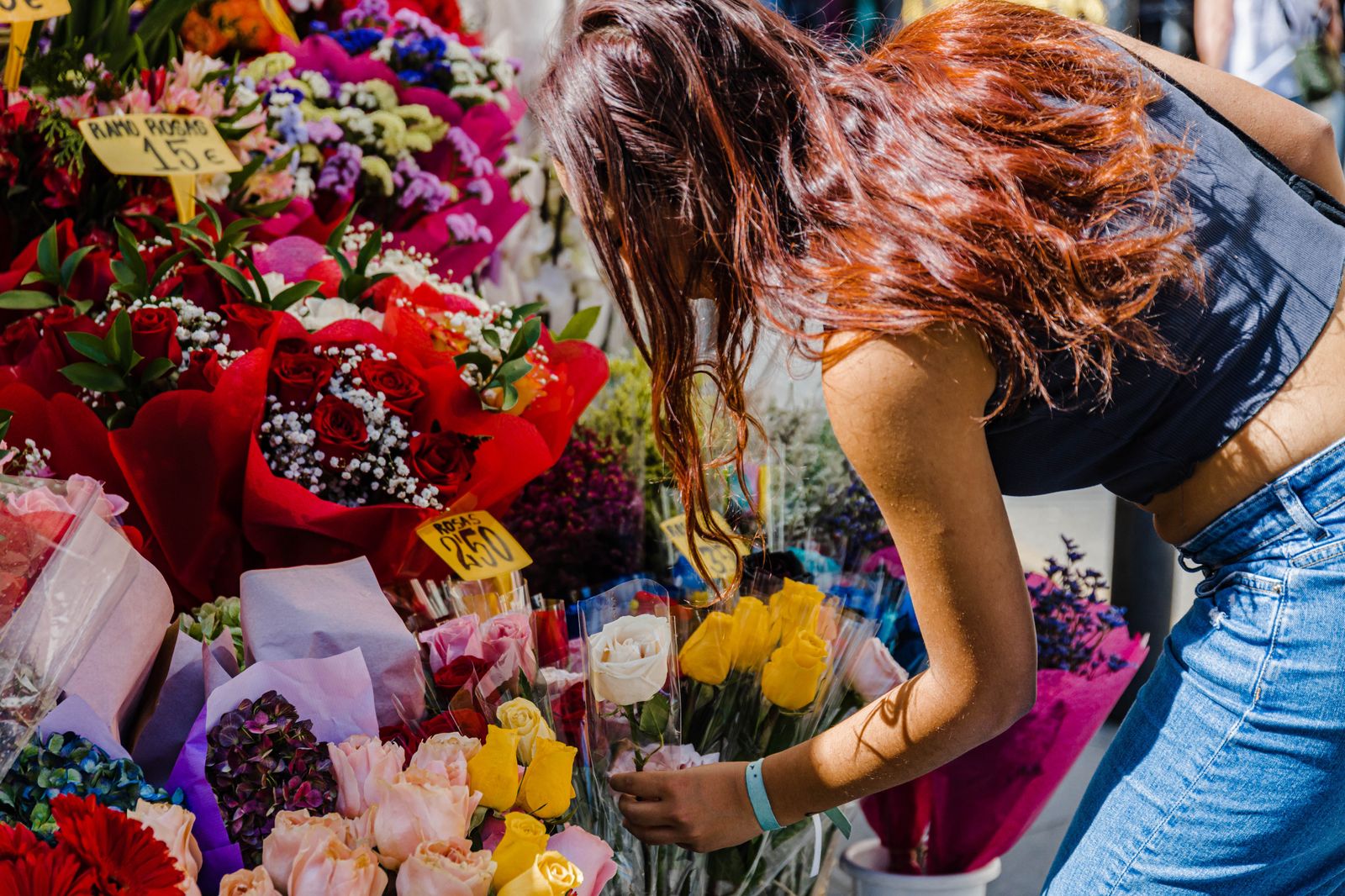 Una mujer compra flores en un puesto de Tirso de molina