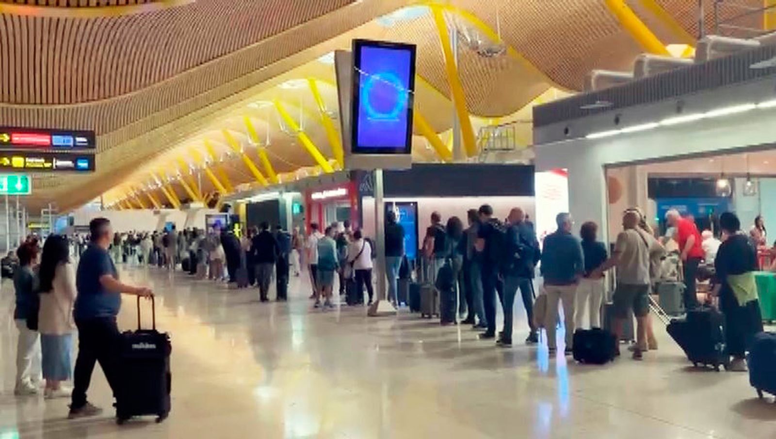 Cola de espera de pasajeros para pasar los controles de seguridad en el Aeropuerto de Madrid Barajas