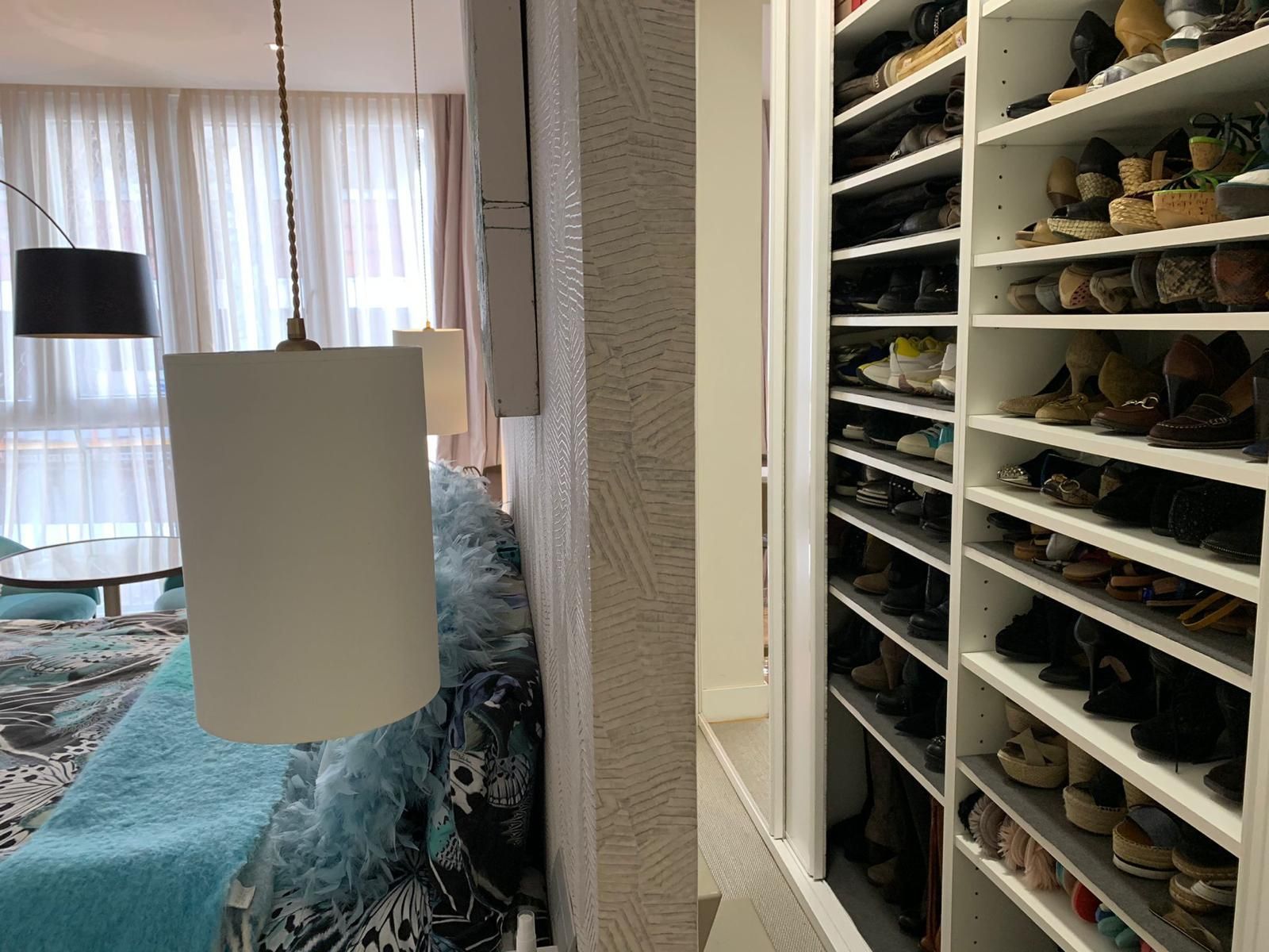Tiene vestidor... y este curioso zapatero escondido tras la cabecera de la cama.