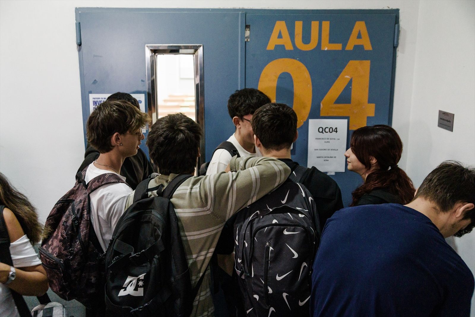 Alumnos esperan en la puerta del aula antes de realizar el primer examen de la PAU 2025