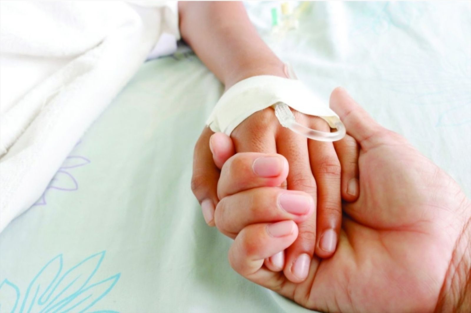 Una persona sostiene la mano de otra mientras se somete a un tratamiento médico