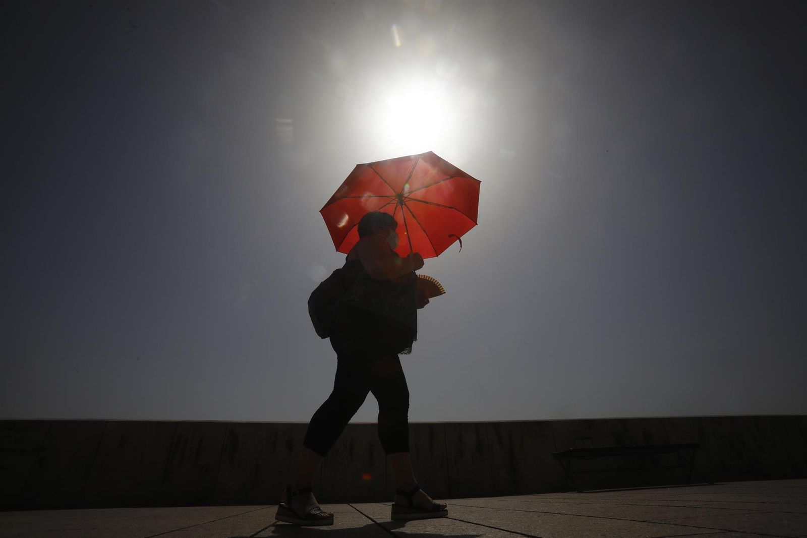 La peor parte de esta ola de calor de aire sahariano se la llevará el sur del país. Esta mujer cordobesa intenta protegerse del sol con un paraguas. Allí los termómetros superarán los 45 grados centígrados.