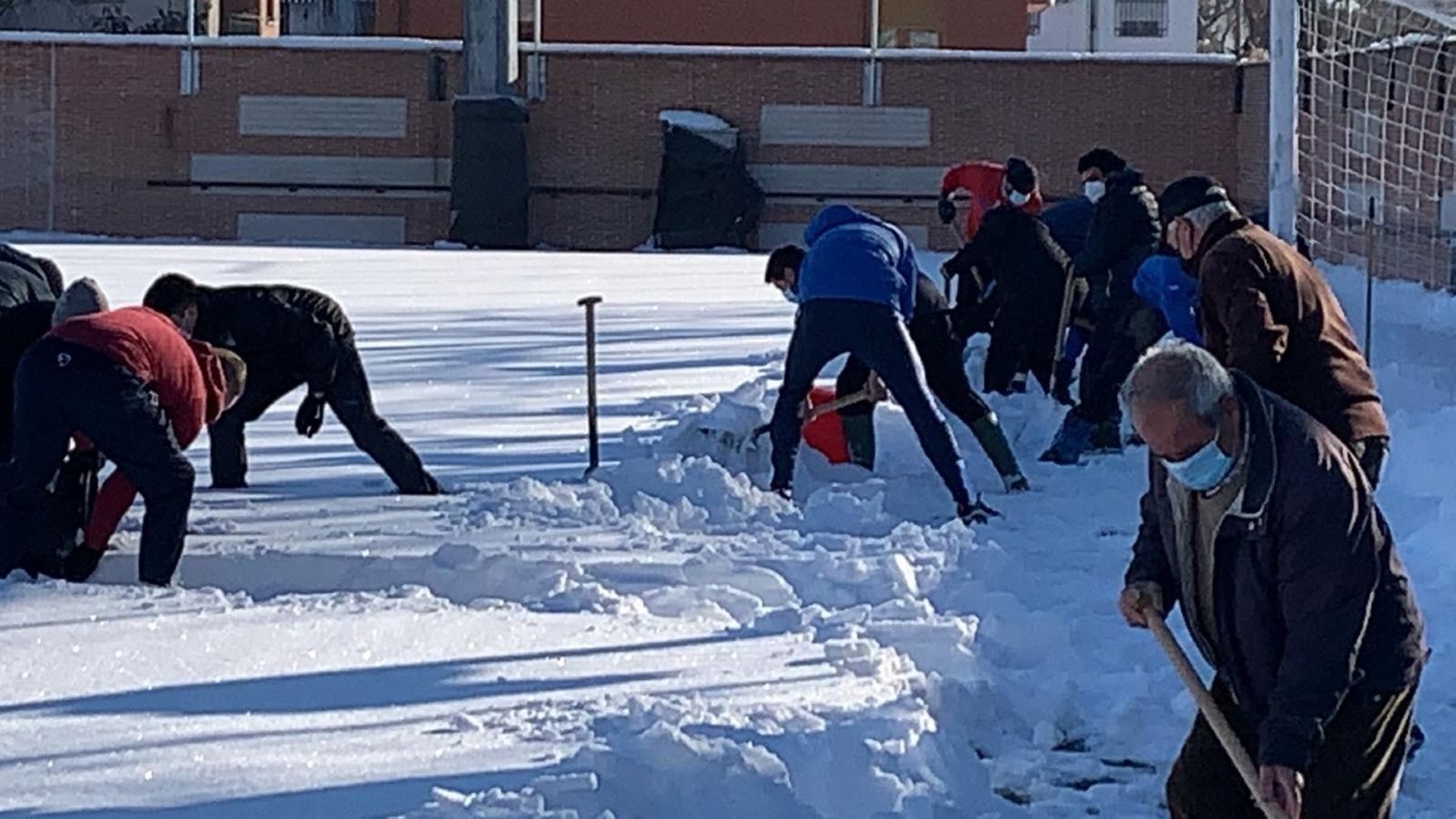 Jugadores y trabajadores del Navalcarnero retiran la nieve