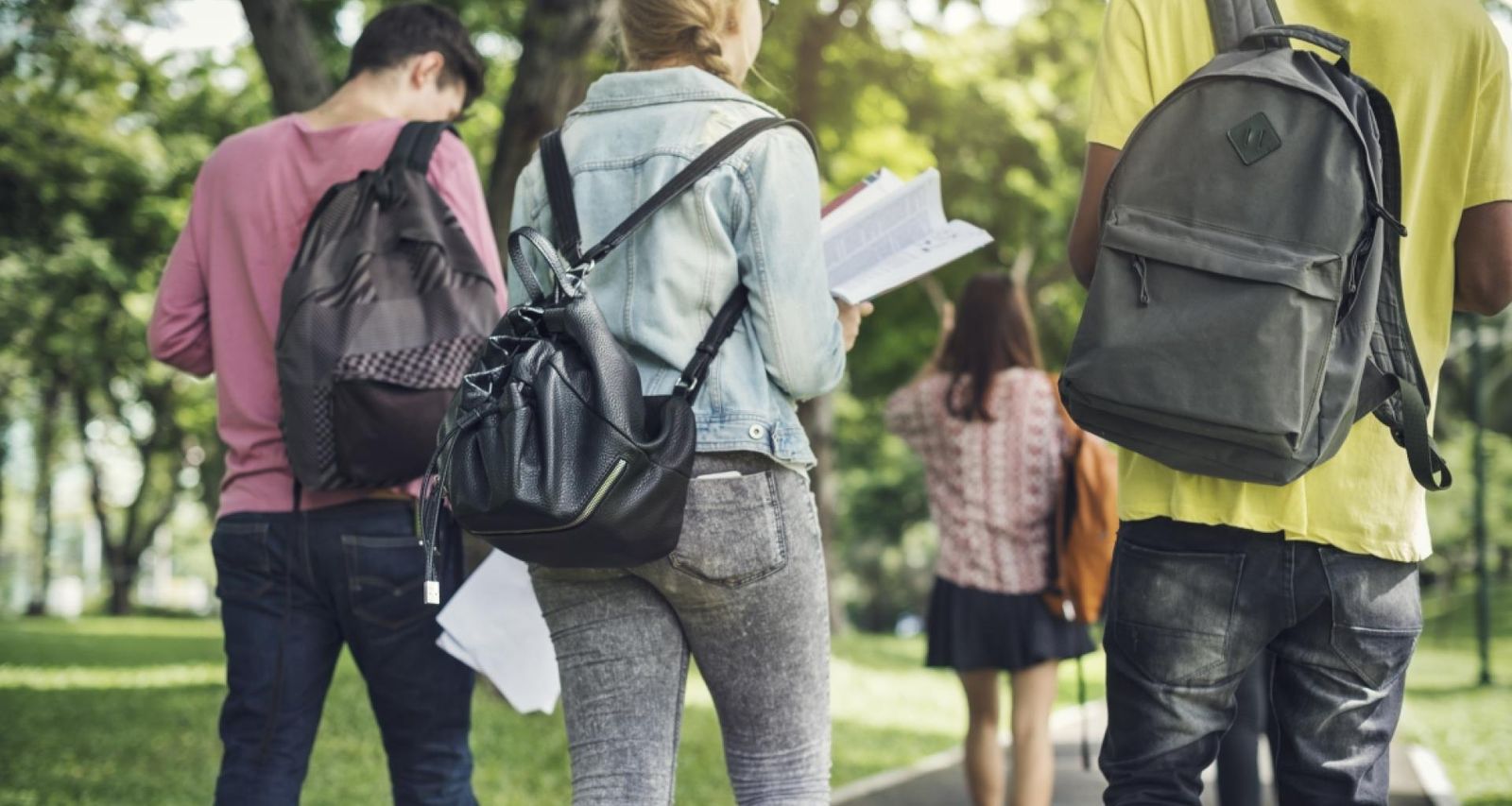 Jóvenes estudiantes caminan con sus mochilas a cuestas