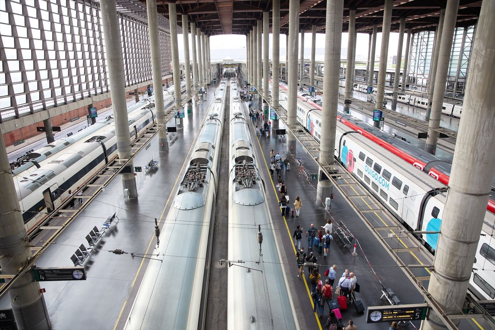 Viajeros con maletas en uno de los andenes de la estación Almudena Grandes-Atocha Cercanías