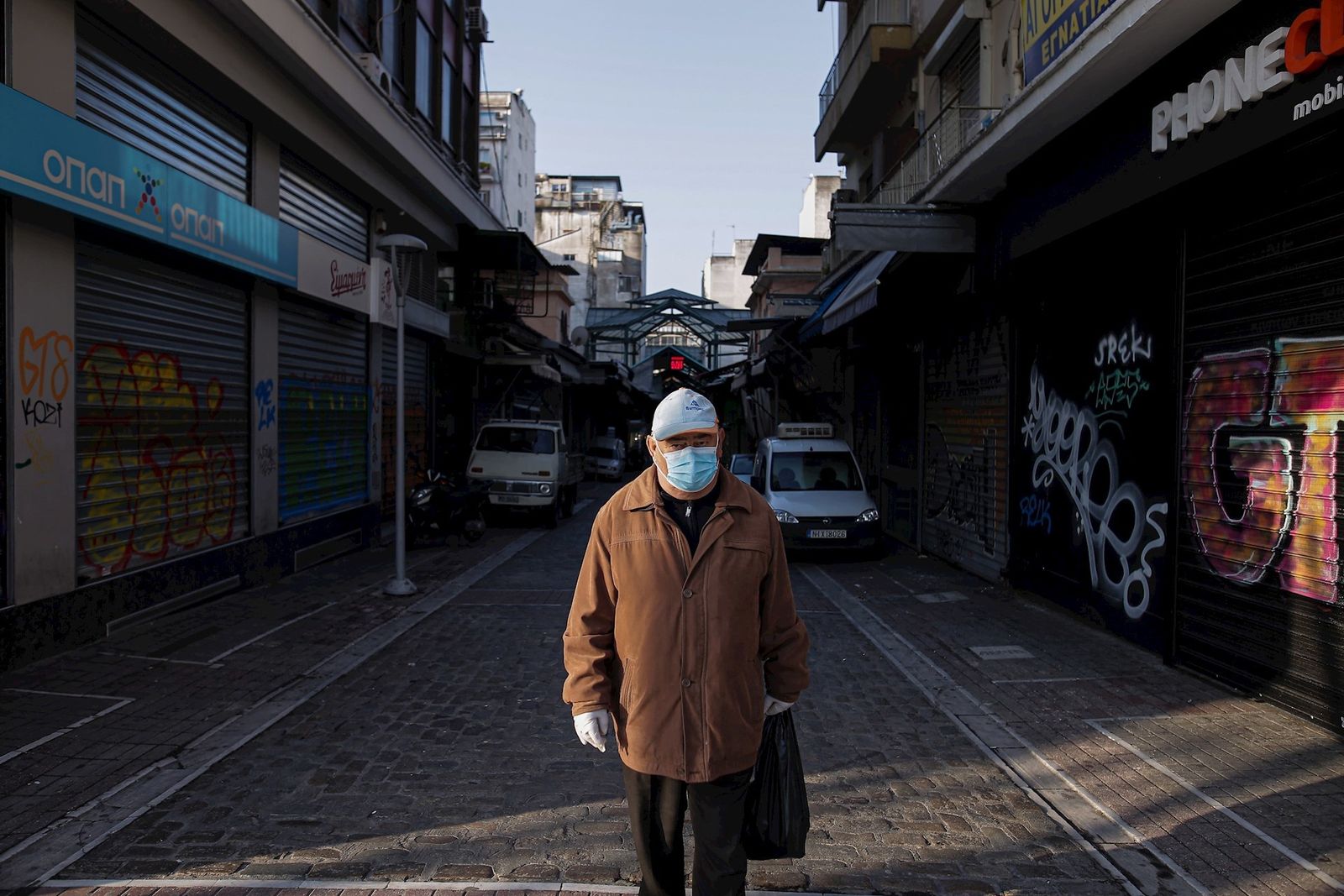 Un hombre con máscara y guantes va a la compra en Tesalónica (Grecia). El país heleno registra más de 1.000 casos y cerca de 40 fallecidos