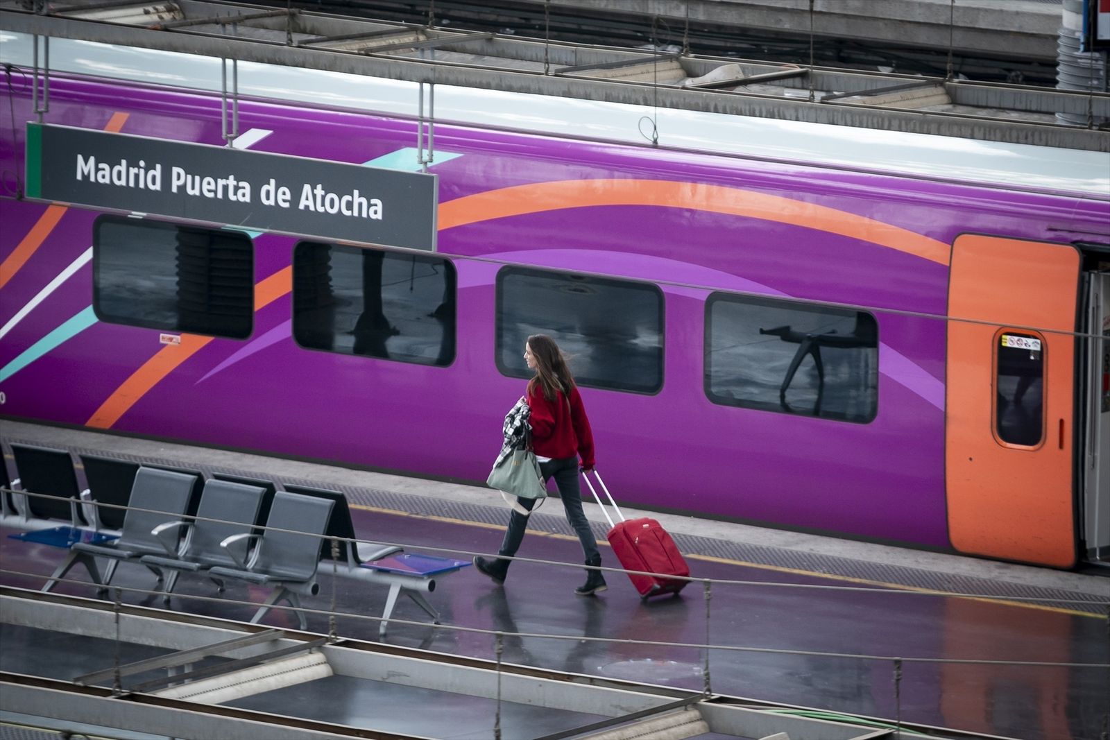 Una mujer con una maleta en la estación Puerta de Atocha-Almudena Grandes junto a un Avlo