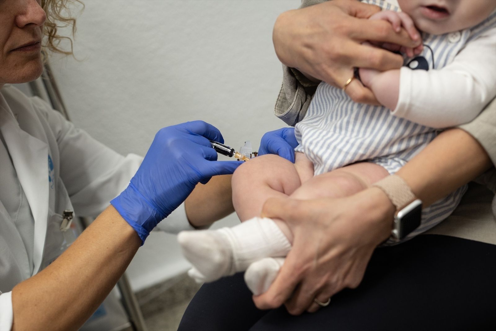 Una sanitaria vacuna a un bebé en un centro de salud de Madrid