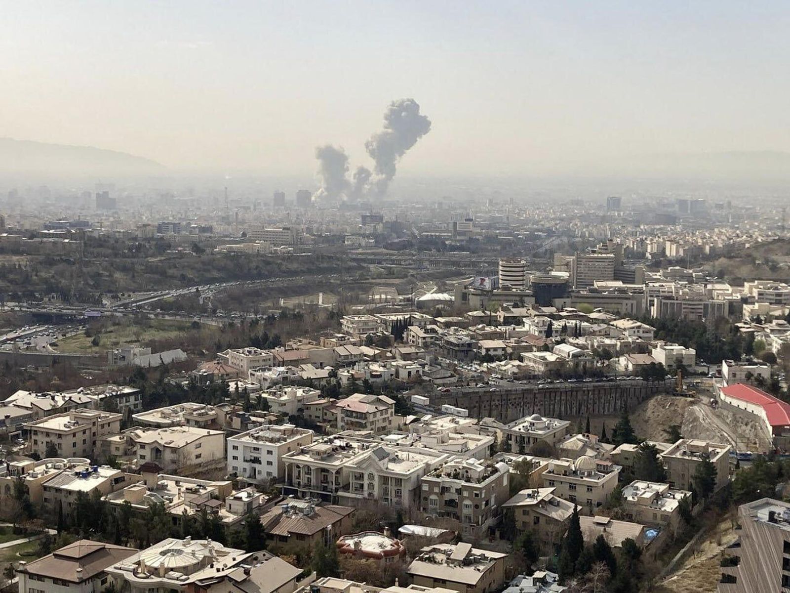Una columna de humo emerge del centro de Teherán tras un ataque israelí este sábado