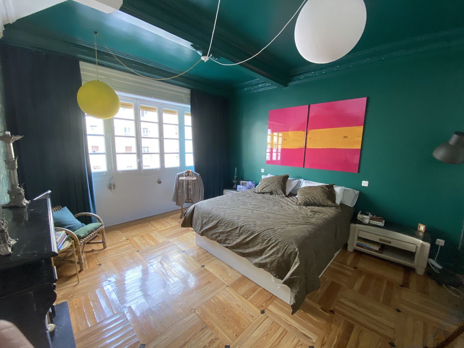 Toda la vivienda sigue el mismo contraste entre los dos colores que presiden paredes y techo. Con algunos detalles que contrastan, como esta fotografía en rosa y amarillo, de Eduardo Marco.
