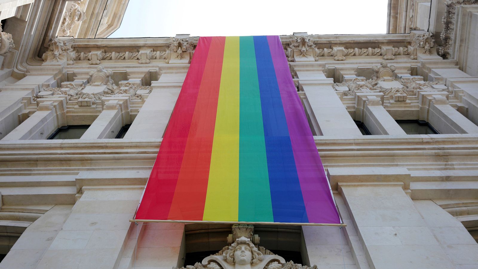 La bandera LGTBI desplegada en la fachada el Ayuntamiento de Madrid