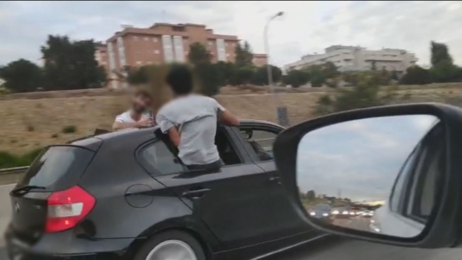Jóvenes en la M-40 circulando en un coche con medio cuerpo fuera