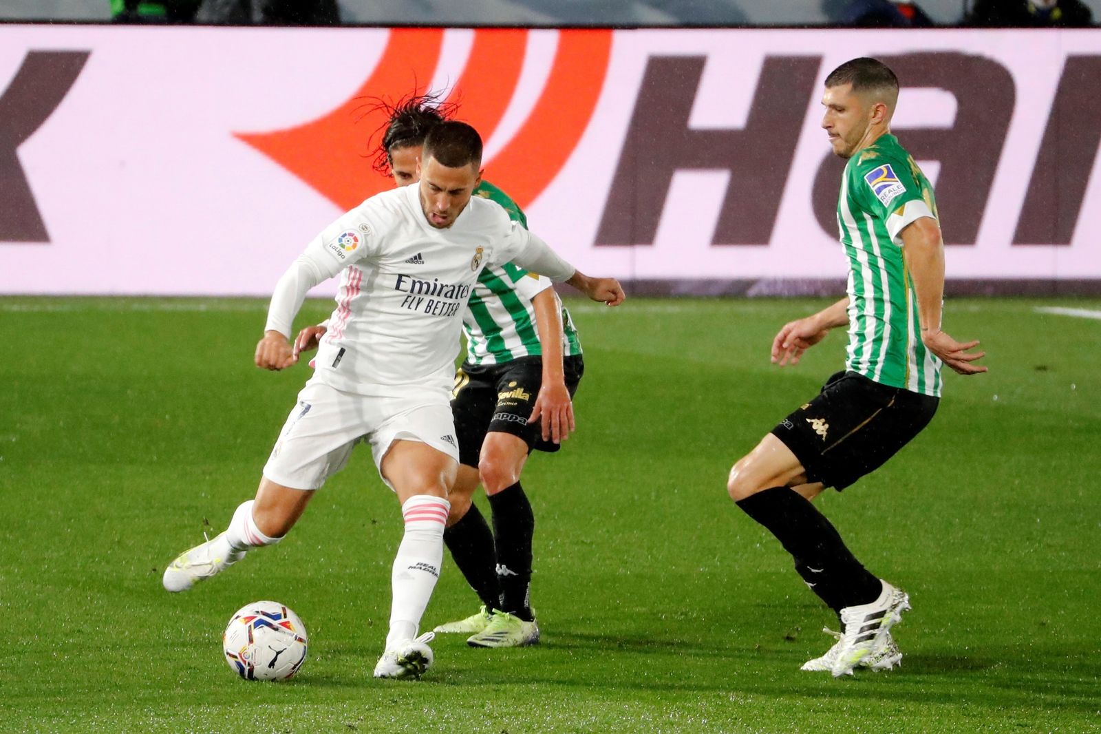 El centrocampista del Real Madrid Eden Hazard juega un balón ante Guido Carrillo