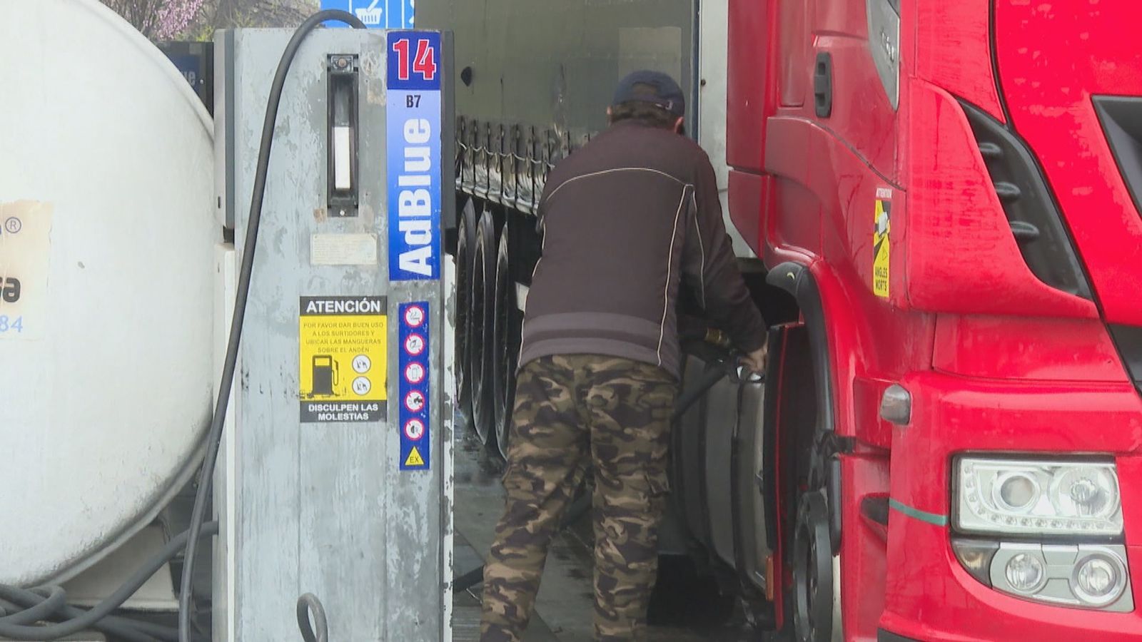 Un camionero echando combustible en su vehículo