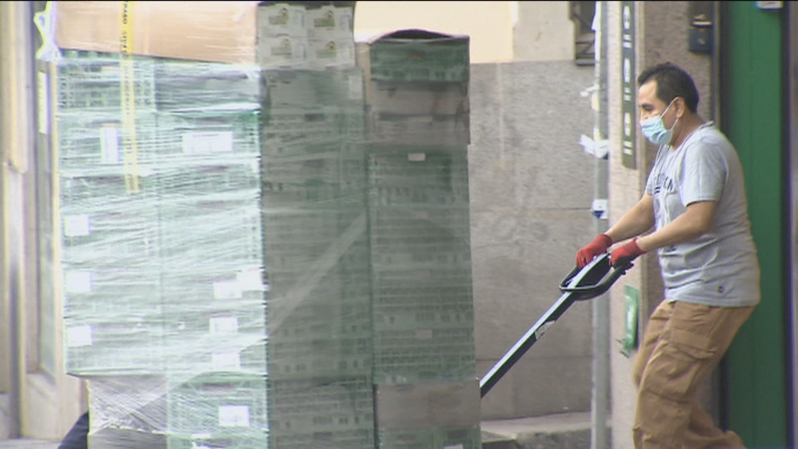 Un trabajador traslada un palé cargado de mercancías
