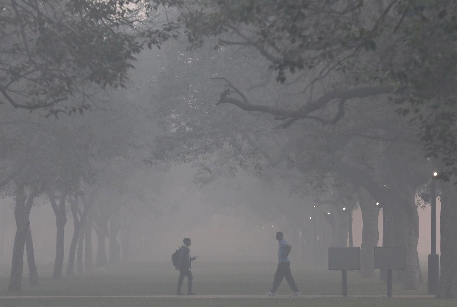 Personas caminan en el interior de la nube tóxica creada en Nueva Delhi estos días