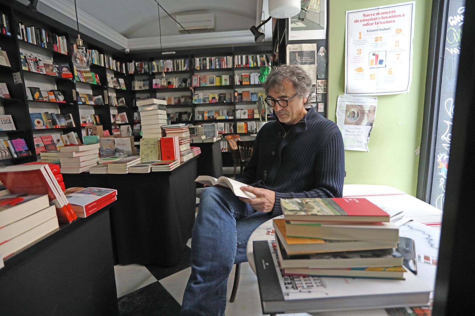 Jesús Trueba lee un libro en su librería 'La buena vida'