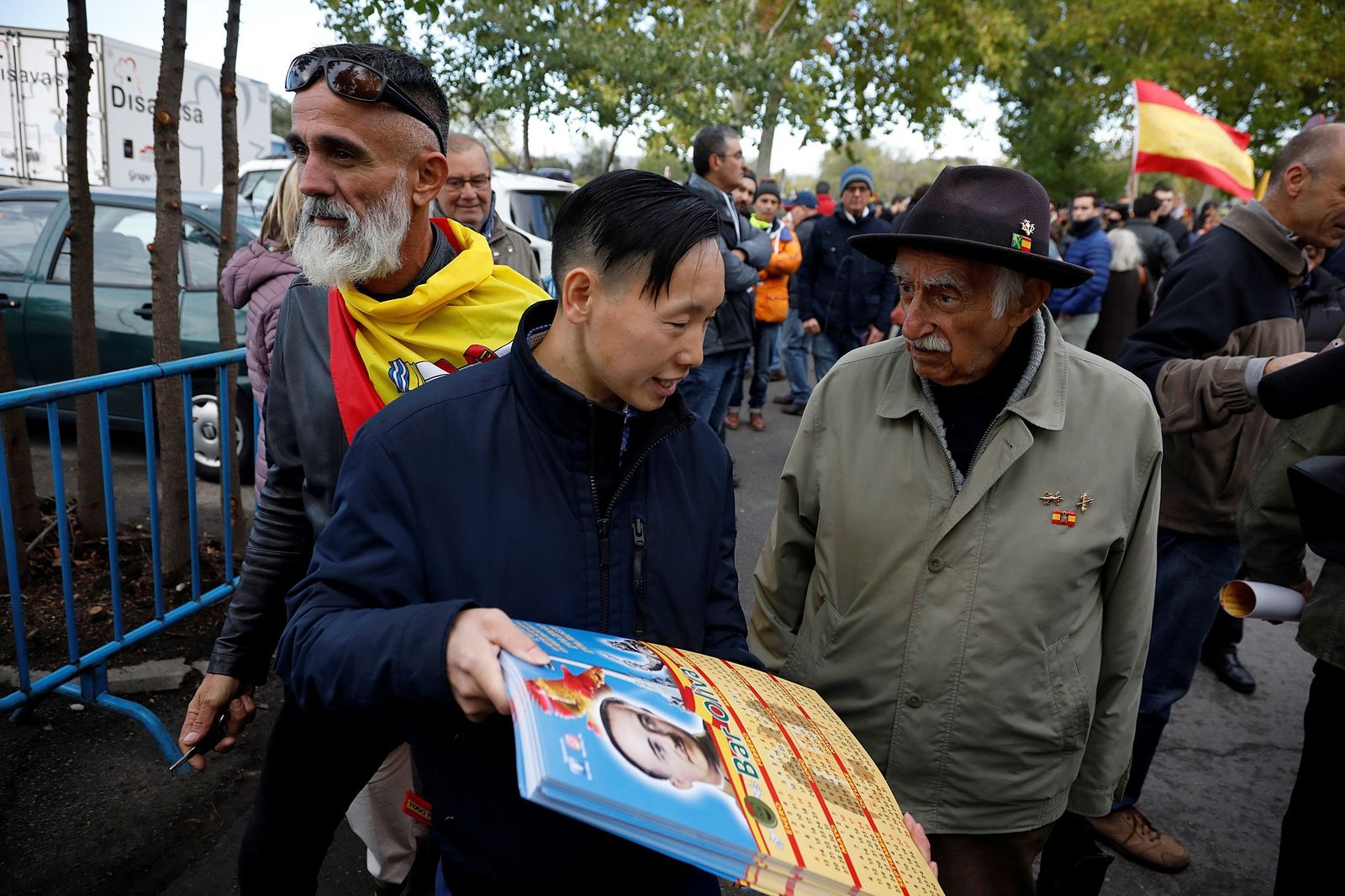 Chen Xiangwei (c), un ciudadano chino que regenta un bar con simbología franquista en Madrid, se concentra junto a otras personas en el acceso del cementerio de El Pardo-Mingorrubio