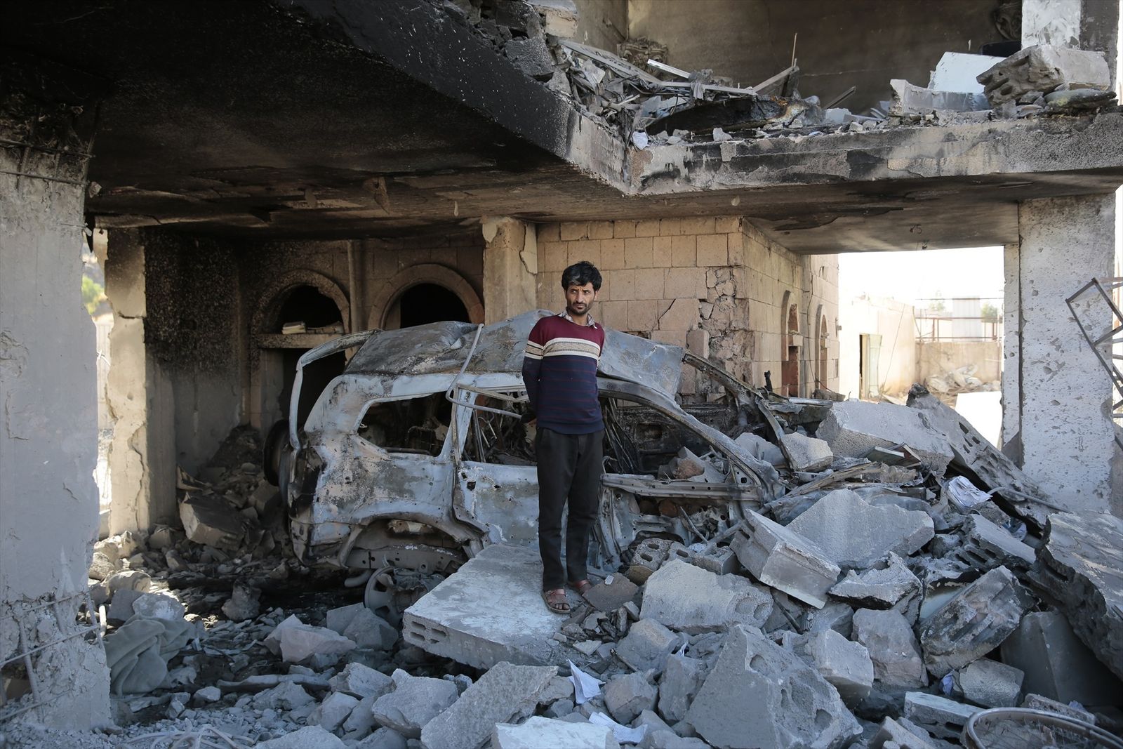 Una persona entre los restos de un edificio tras un ataque aéreo en Sanaa