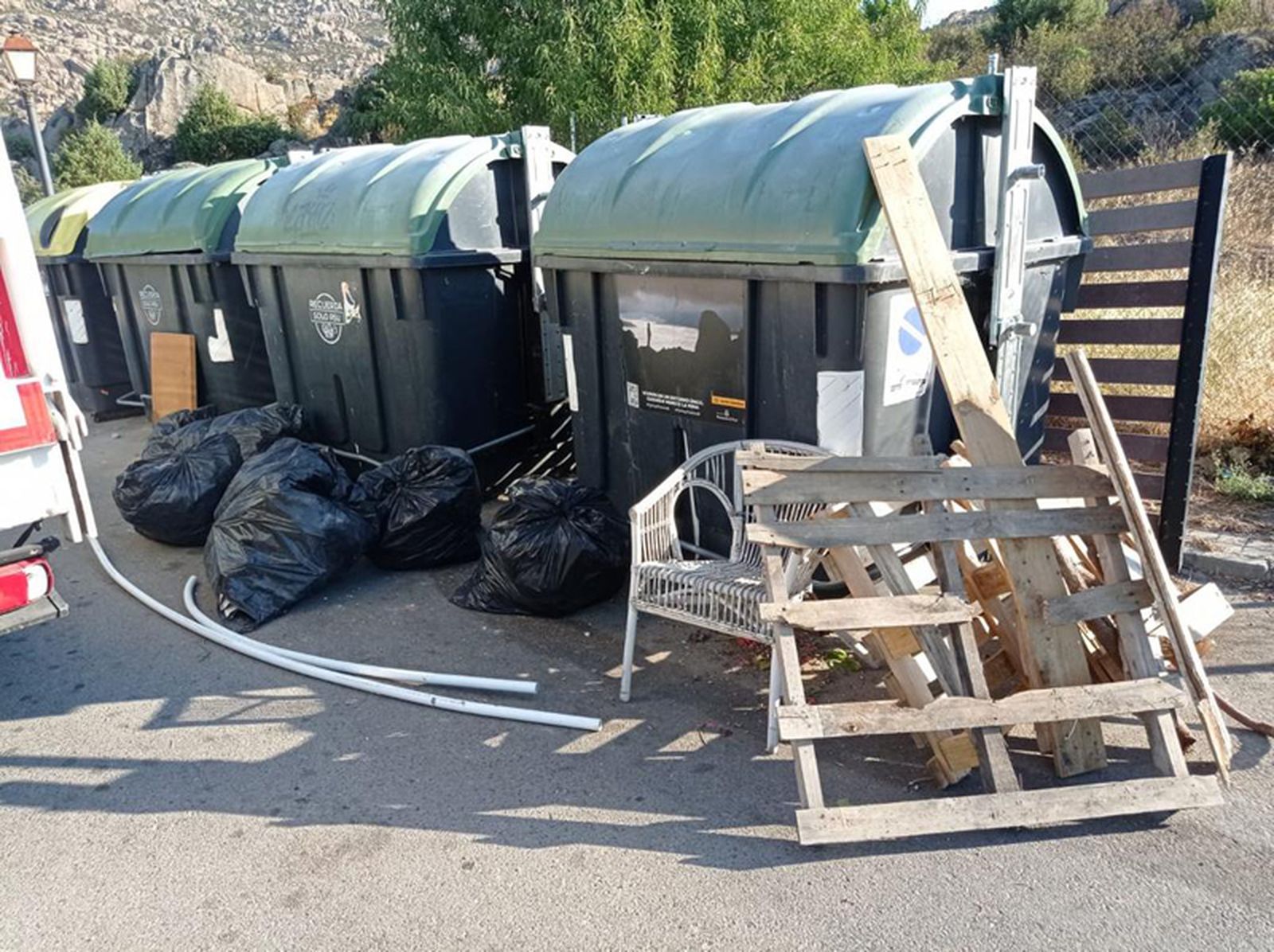 Restos de mobiliario y otros residuos depositados junto a contenedores de basuras domésticas