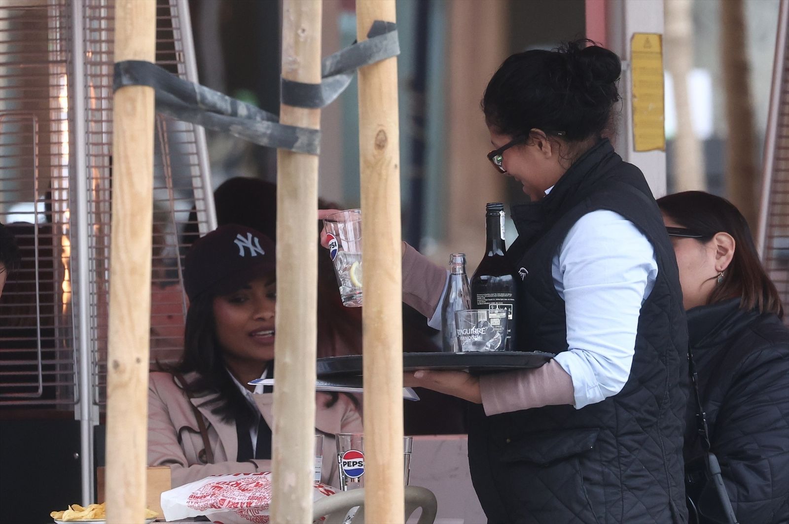 Camarera atendiendo a los clientes de un bar
