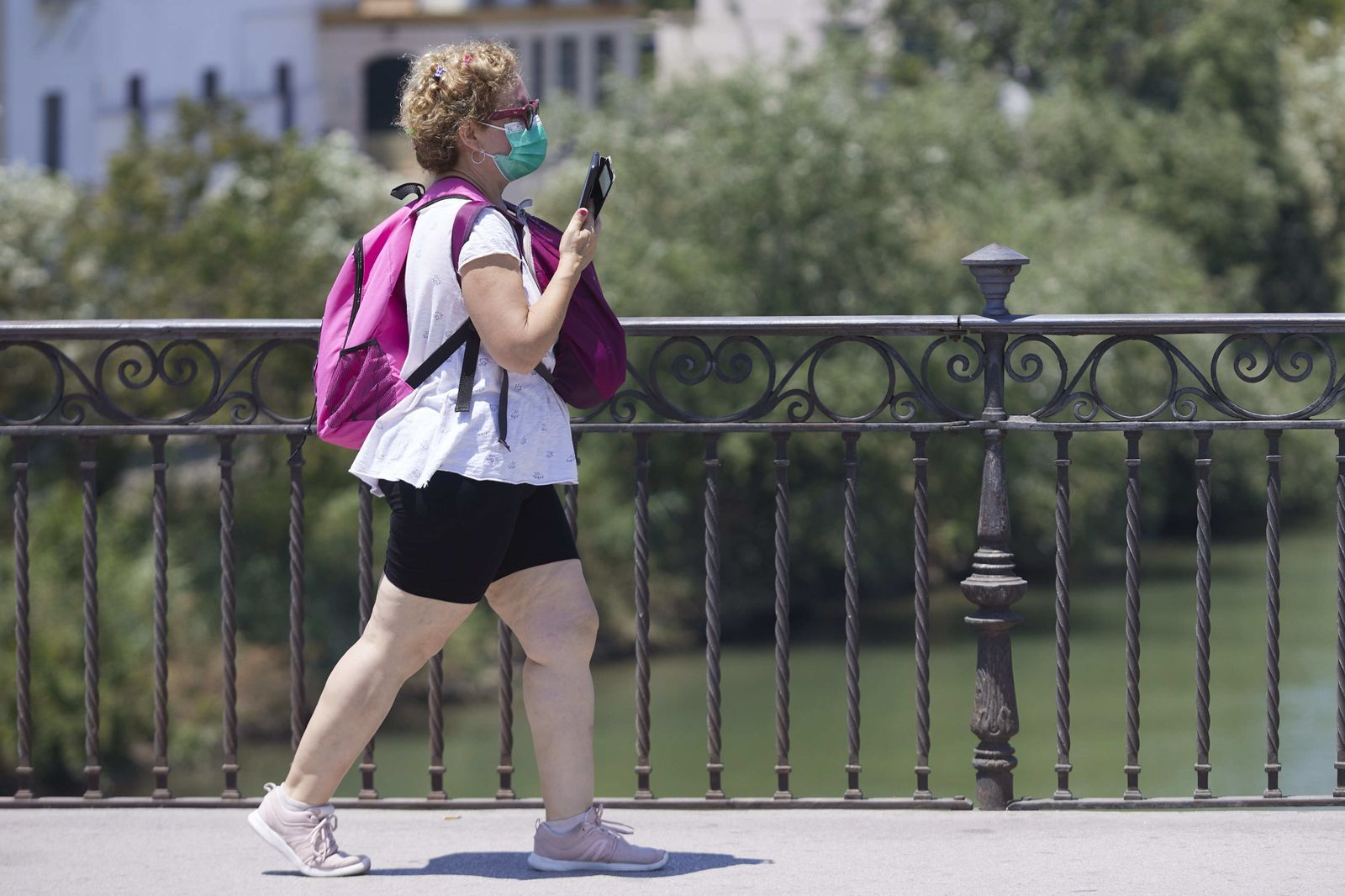 Una mujer con mascarilla, paseando por la calle