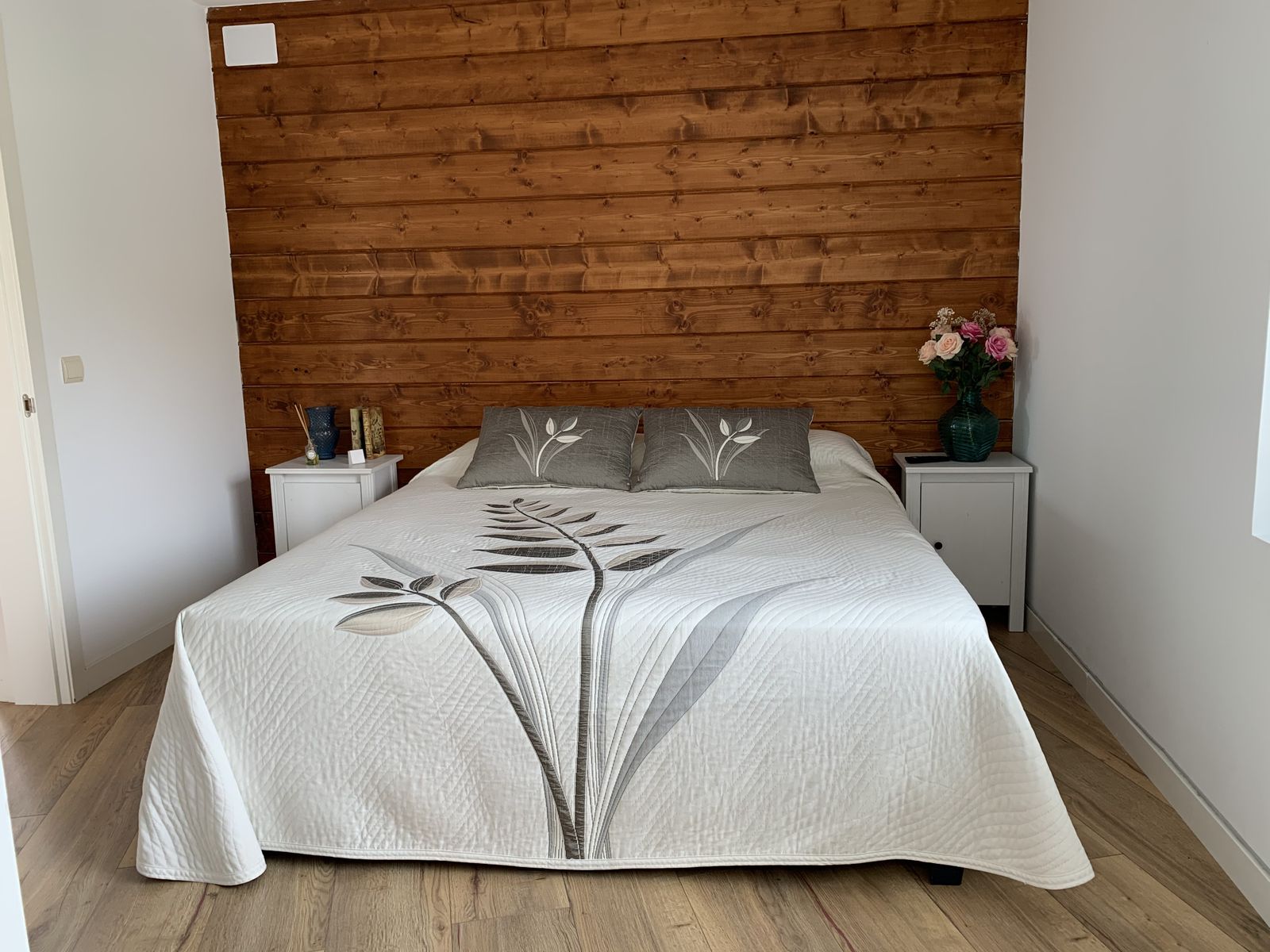 El cabecero de la cama es una pared forrada de madera.