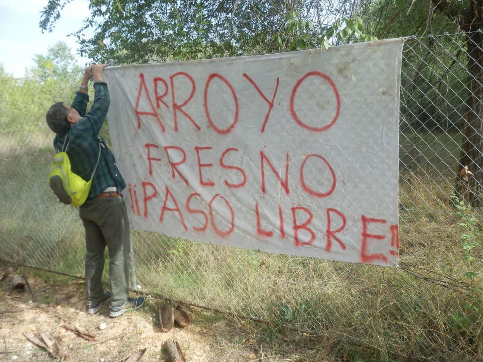 Una persona coloca una pancarta reclamando el acceso a una parte del camino