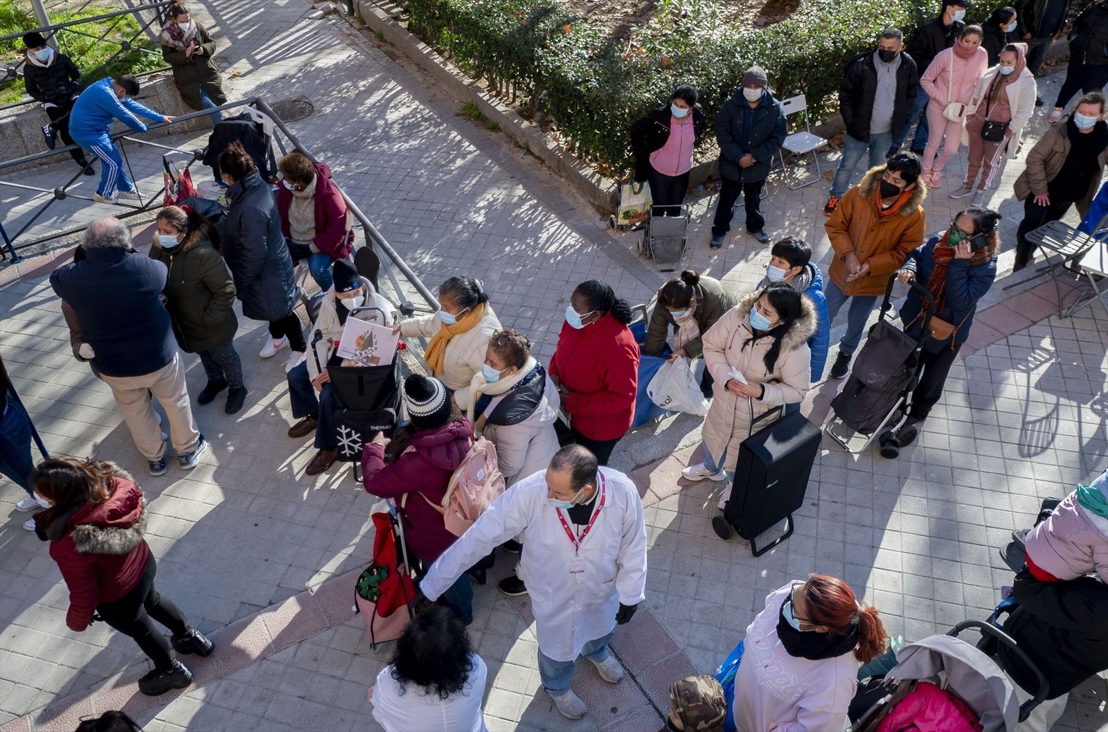 Varias personas hacen cola para recibir alimentos de la Fundación Madrina
