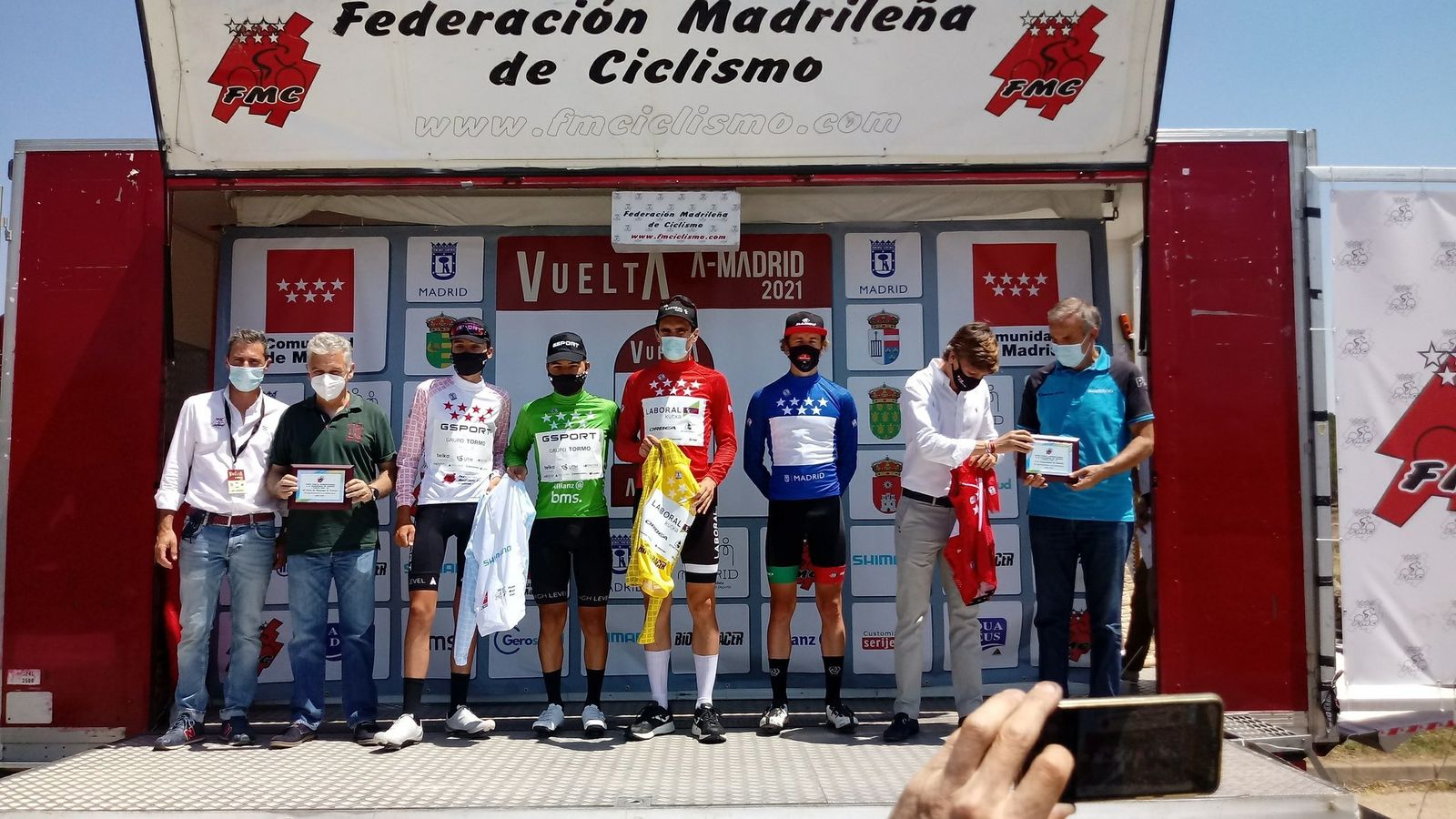 Podio final con los laureados de la segunda etapa con el líder en el centro