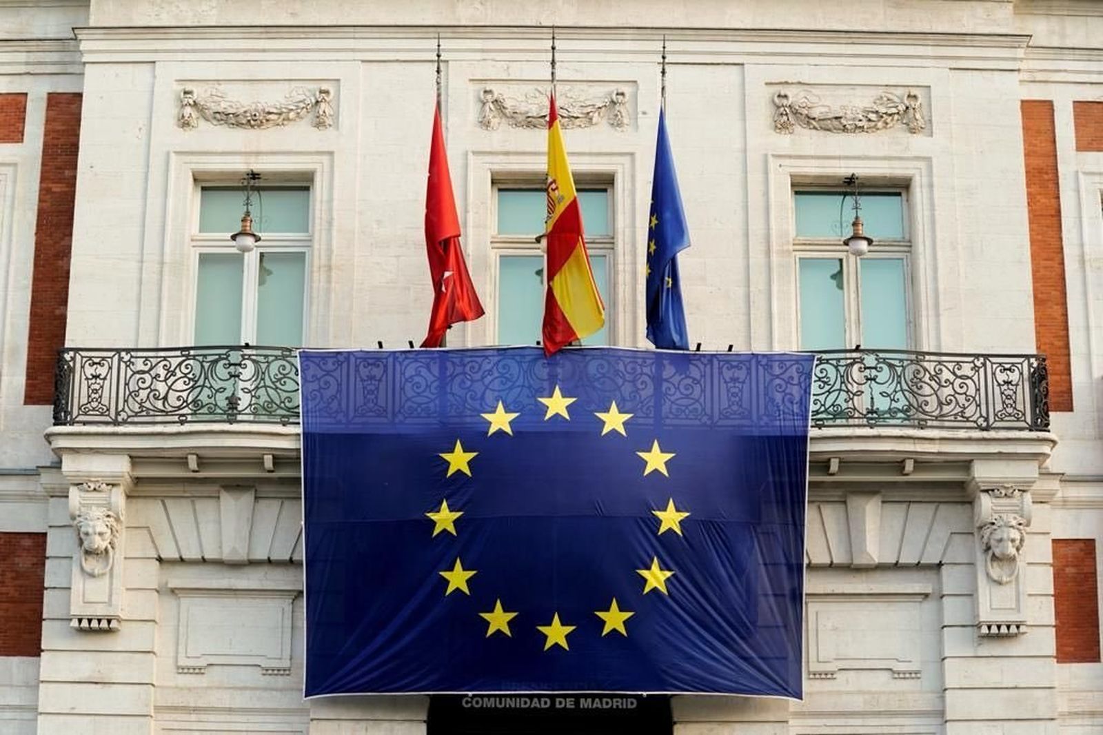 La fachada de la Real Casa de Correos luce la bandera de la Unión Europea para conmemorar su día