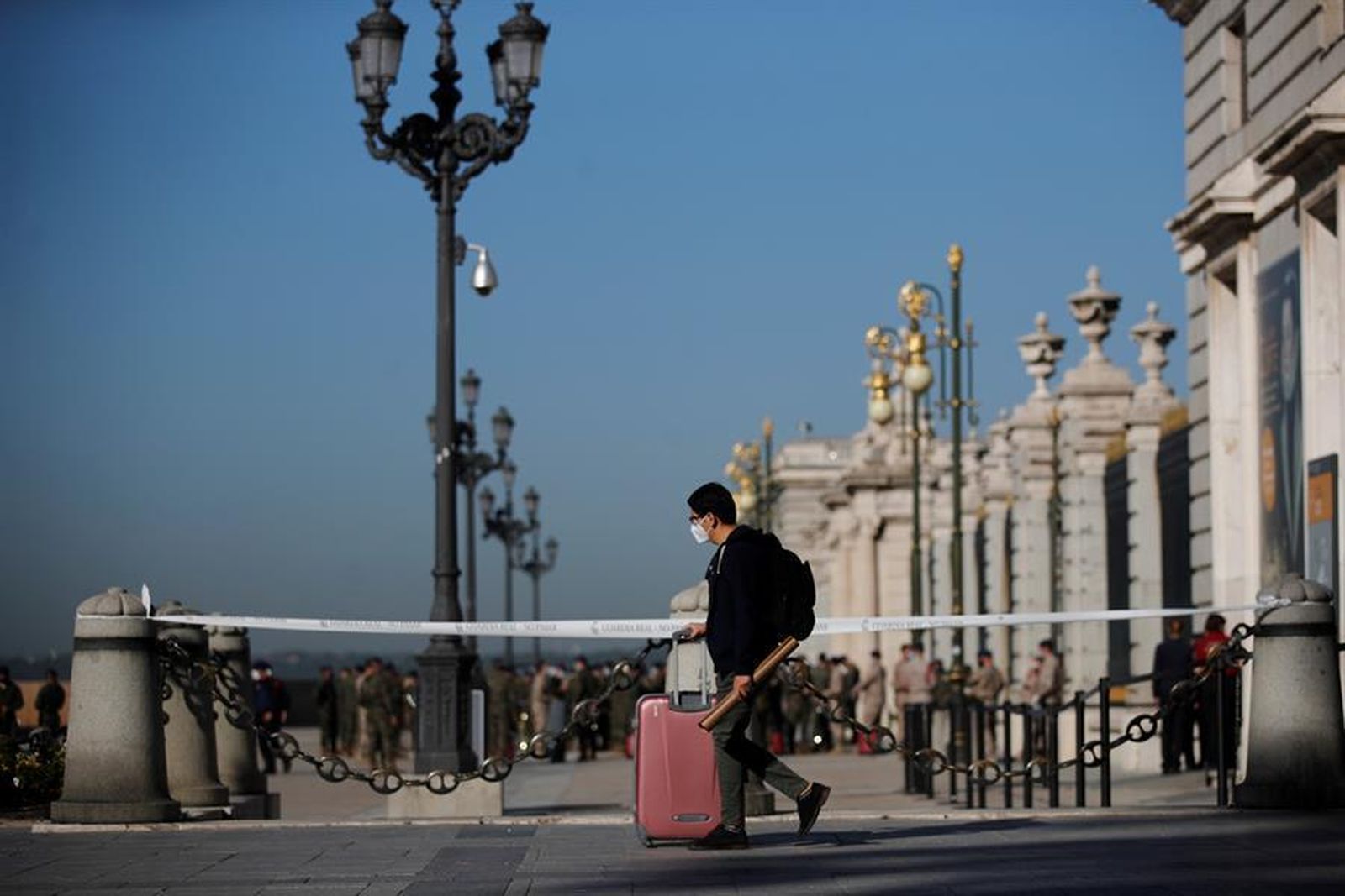 Un joven pasa junto al Palacio Real de Madrid