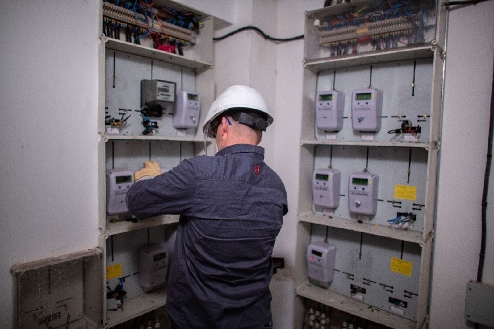 Un operario revisa varios contadores eléctricos de la luz